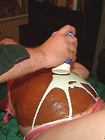 Pregnant girl with pink hair gets her belly covered with food