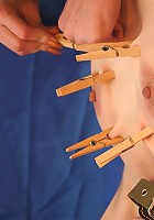 Bound slave girl gets clothespins all over her body