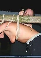 Blonde slave gets tied up to a stick with an onion on her mouth