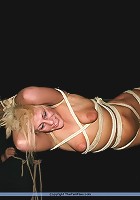 Blonde slave gets tied up to a stick with an onion on her mouth