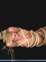 Blonde slave gets tied up to a stick with an onion on her mouth