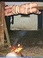 Blonde slave gets tied up to a stick with an onion on her mouth