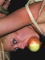 Blonde slave gets tied up to a stick with an onion on her mouth