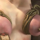 19yr old with huge natural tits is suspended to a wallher breasts are tied to hold up her legs.